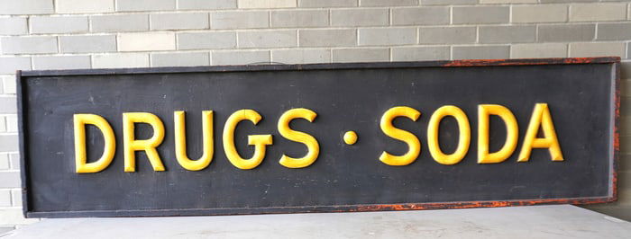 Large drug store sign with applied yellow letters "DRUGS * SODA", late 19th to early 20th century.