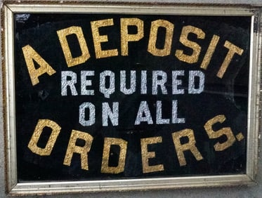 A tinsel advertising sign, gold and silver lettering on painted black ground, marked "A DEPOSIT