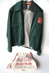 A Coca Cola truck driver's uniform that includes a jacket, shirt, and apron, circa 1950-60. Good
