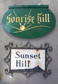 Two signs "SUNSET HILL" and "SUNRISE HILL" signs. The first, circa 1930, has a scrolled metal frame