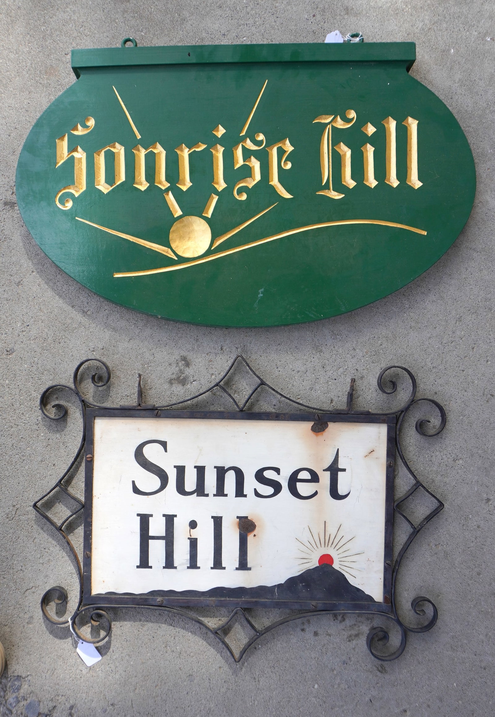Two signs "SUNSET HILL" and "SUNRISE HILL" signs. The first, circa 1930, has a scrolled metal frame: Two signs "SUNSET HILL" and "SUNRISE HILL" signs. The first, circa 1930, has a scrolled metal frame and besides the name is decorated with a setting sun over mountain top - measures - 25" x 19" -very 