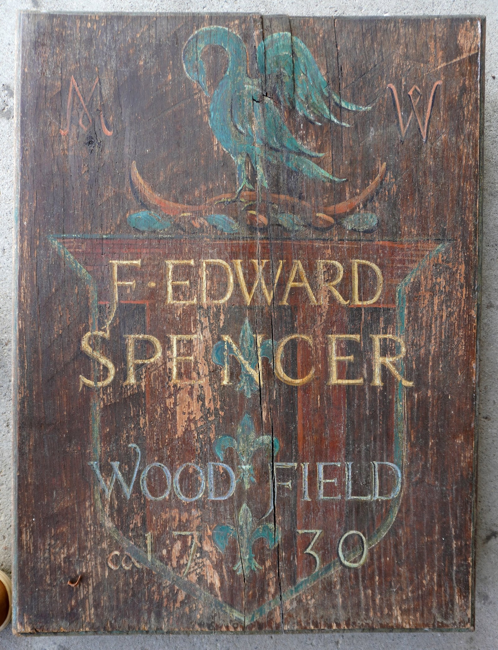 A hand made and hand painted heavy wooden country estate or tavern sign marked within shield "F.: A hand made and hand painted heavy wooden country estate or tavern sign marked within shield "F. Edward Spencer / Woodfield / Ca. 1730" over a hand painted image of a swan flanked by the initials "M. 