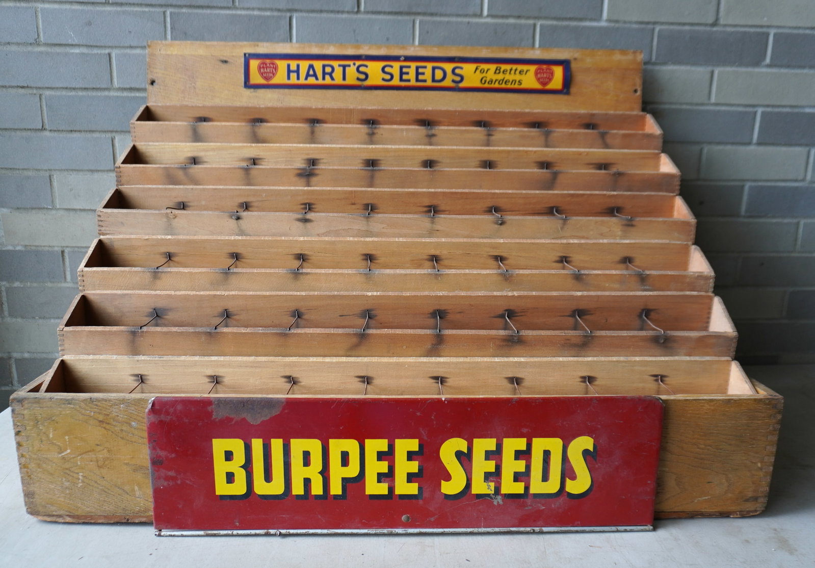 Two advertising articles including: A lithographed tin 'BURPEE SEEDS" sign, yellow lettering on red: Two advertising articles including: A lithographed tin 'BURPEE SEEDS" sign, yellow lettering on red ground - some rust spots and losses but overall good condition - measures 21 1/2"L x 6 1/4"H; togeth