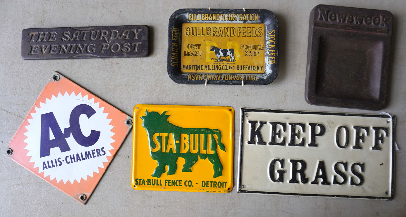 Grouping of 6 tin and iron advertising articles including: "Keep Off The Grass" tin sign; cast iron: Grouping of 6 tin and iron advertising articles including: "Keep Off The Grass" tin sign; cast iron "THE SATURDAY EVEING POST" double sided paper weight - 8"L; NEWSWEEK cast iron ashtray or coin tray;