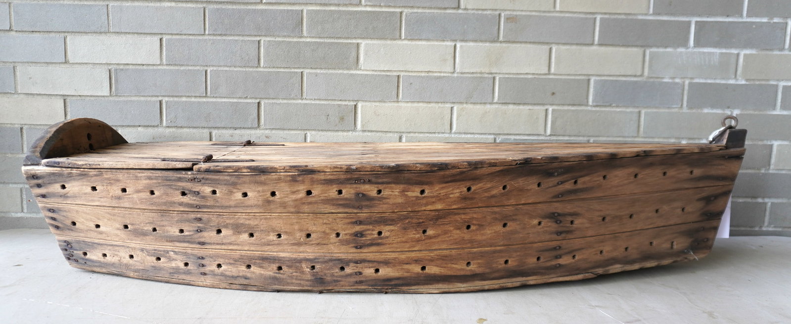 A hand made boat shaped wooden livewell, for storing live bait or the recent catch, and made to be: A hand made boat shaped wooden livewell, for storing live bait or the recent catch, and made to be pulled behind by fishing vessel to keep fish fresh, circa 1950. Not many of these wooden vessels have