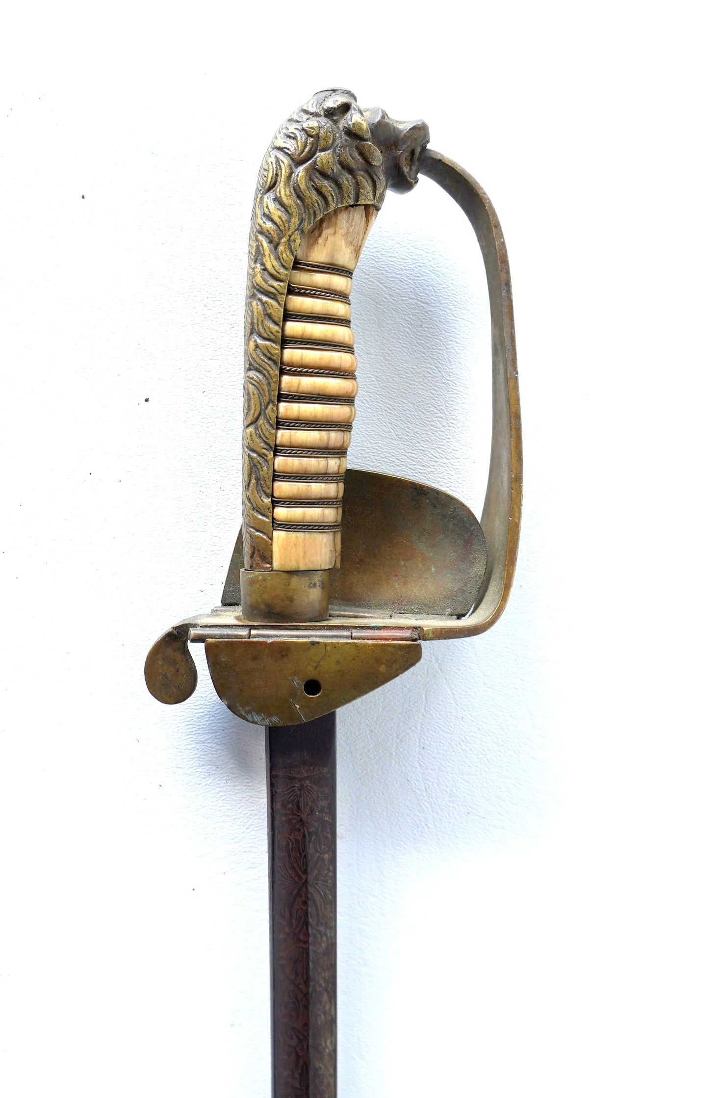 A German officer's eagle-head sword having a folding hand guard decorated with an embossed anchor,: A German officer's eagle-head sword having a folding hand guard decorated with an embossed anchor, and also having an engraved blade, signed P.O. & Co., probably WWI or earlier. Missing scabbard, else