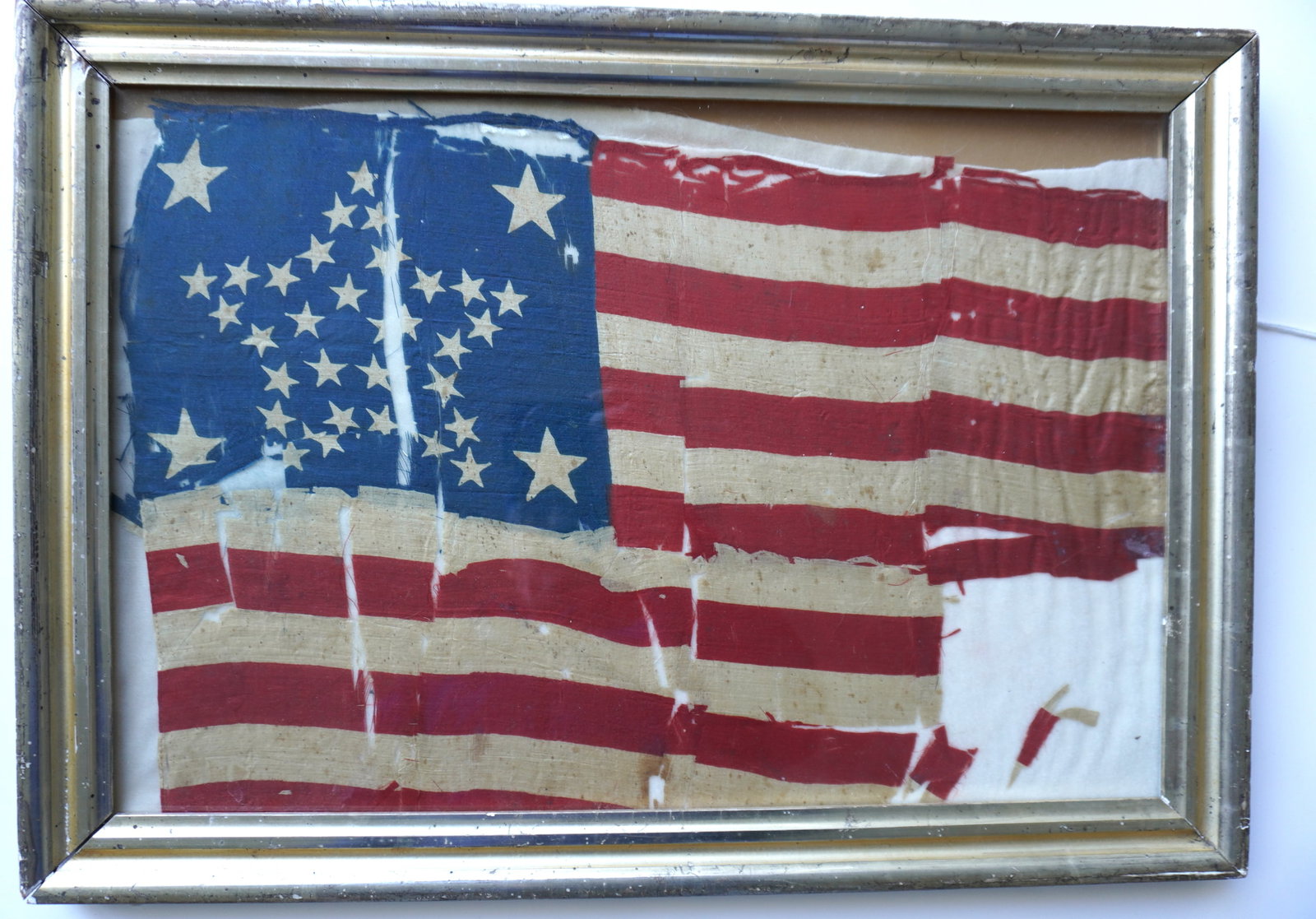 A Civil War printed flag with 34 stars in a variation of the Great Star pattern, 1861-1863. Poor: A Civil War printed flag with 34 stars in a variation of the Great Star pattern, 1861-1863. Poor overall condition with tears, stains and losses. Note on reverse indicates this was a battlefield flag 