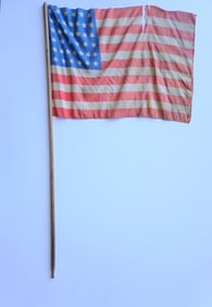 An American 39 star parade flag attached to original wooden post. Two tears and small hole in the