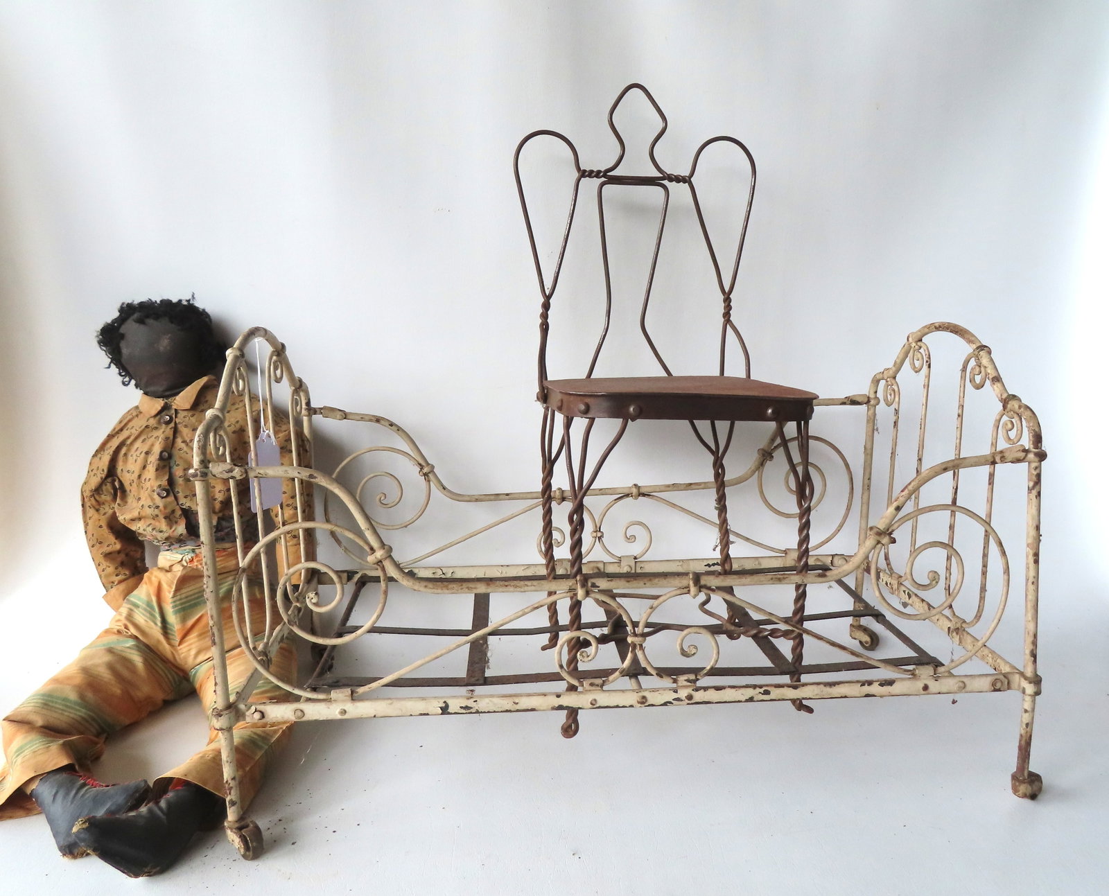 Three doll related toys including a fancy wire and iron bed, late 19th to early 20th century, on: Three doll related toys including a fancy wire and iron bed, late 19th to early 20th century, on wheels, in old white paint and in good condition - measures 24 1/2"L x 14 1/4"W x 15 1/2"H; a 1950's Bl
