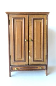 A primitive hand made doll's cupboard having 2 paneled doors over lower paneled drawer, constructed