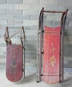 Two stenciled and hand painted child's sleds in original paint, both decorated with flowers, late