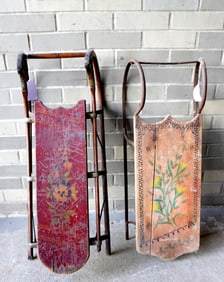 Two child's sleds decorated with hand painted flowers, late 19th century. Both with expansion crack,