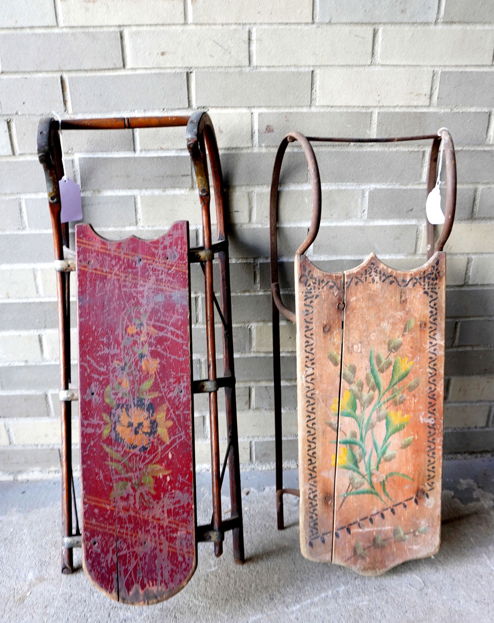 Two child's sleds decorated with hand painted flowers, late 19th century. Both with expansion crack,: Two child's sleds decorated with hand painted flowers, late 19th century. Both with expansion crack, otherwise good condition. The largest measures 29 1'2"L x 12 1/4"W. Provenance: From the Marni Baks