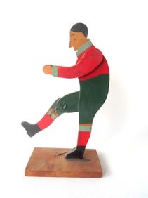 A folk art mechanical wooden football or soccer kicker toy in original paint, circa 1920-30. Good