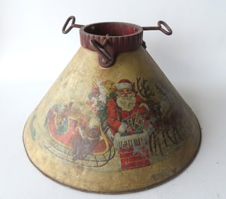 A lithographed tin and iron Christmas tree holder, decorated with Santa and reindeer on the front