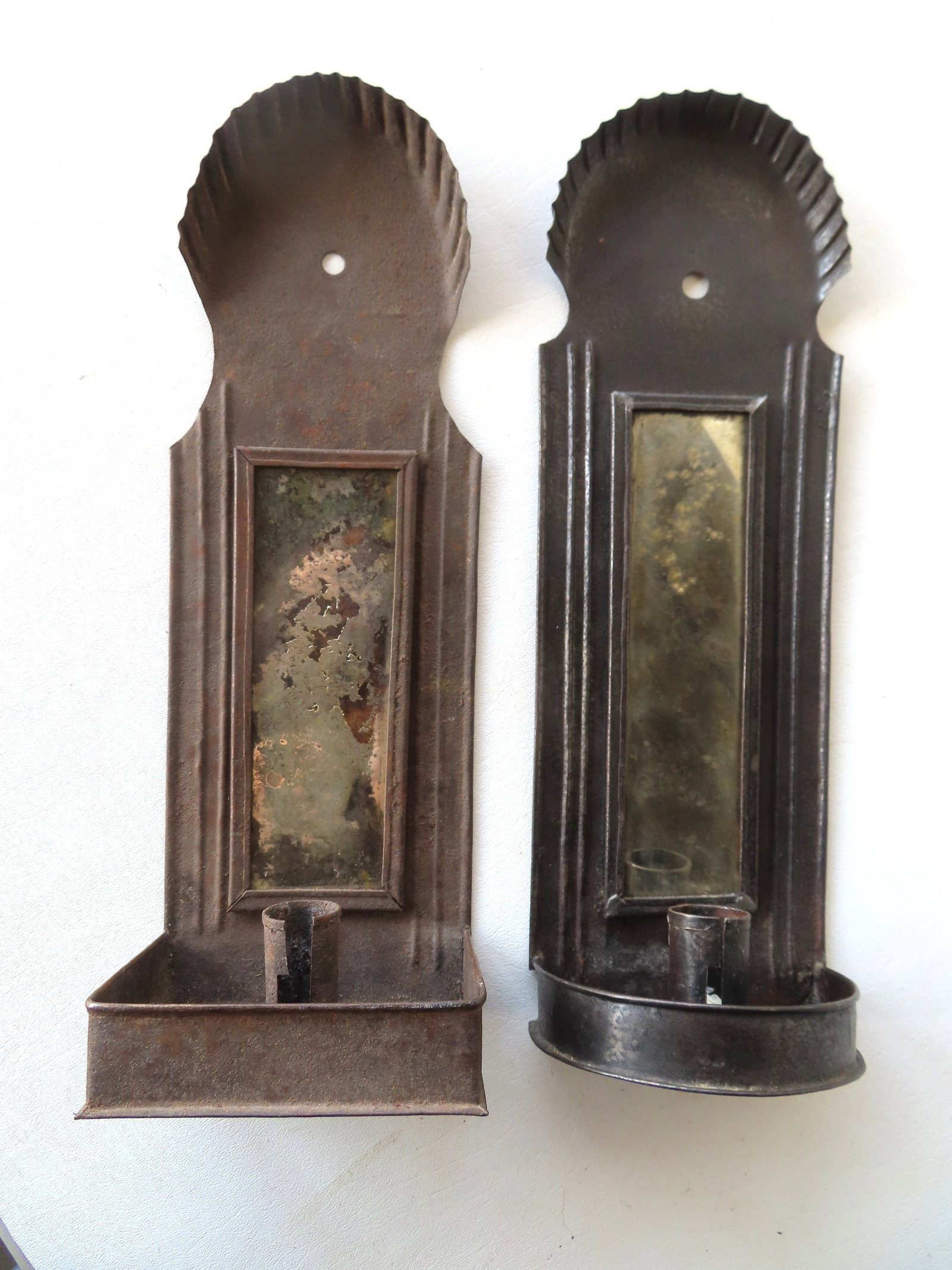Two early tin candle wall sconces, late 18th to early 19th century.: Two early tin candle wall sconces, late 18th to early 19th century. The first with crimped dome top, mirror back, and 1/2 round candle holder at base - good condition - measures 14 1/4"H x 4 5/8"W x 3