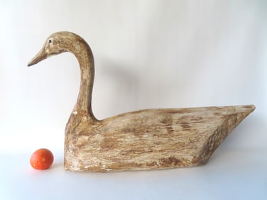 A stately swan decoy with glass eyes and solid carved wooden body construction, late 19th to early 2