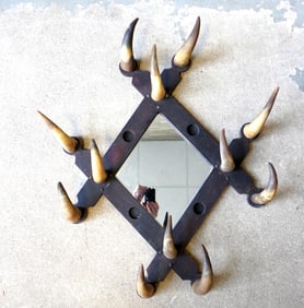 A rustic hat rack with mirror back, having applied cow horns around border, late 19th century, good
