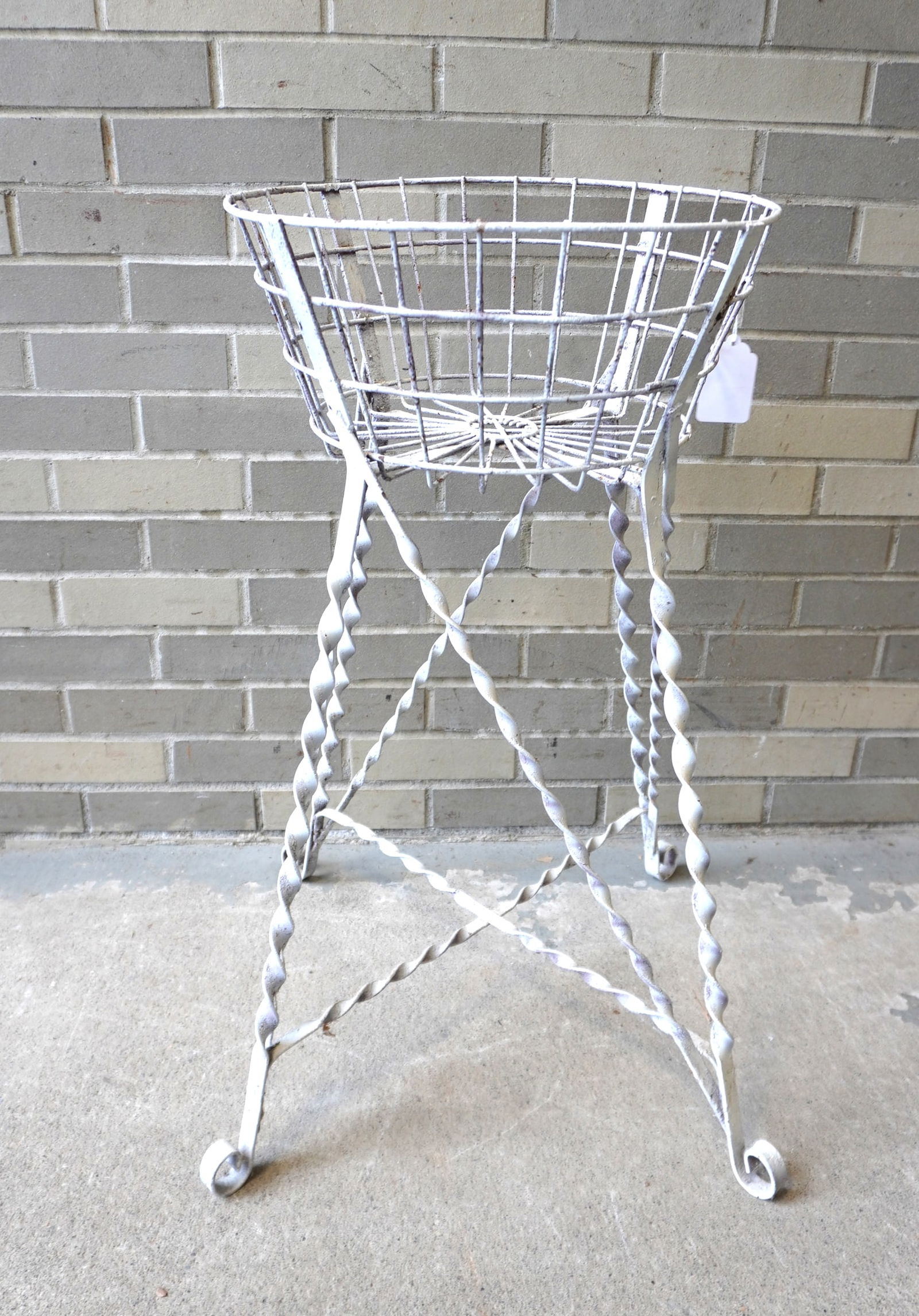 A Victorian wire sewing basket (or plant stand) on wrought iron stand with twisted legs leading to (1 of 3)