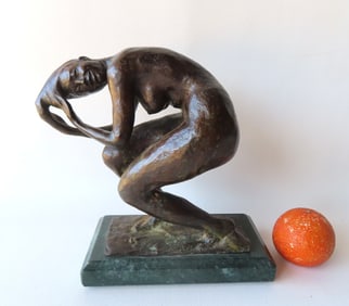 A bronze sculpture of a crouching nude lady washing her hair, signed illegibly….Measures 10 1/2"W