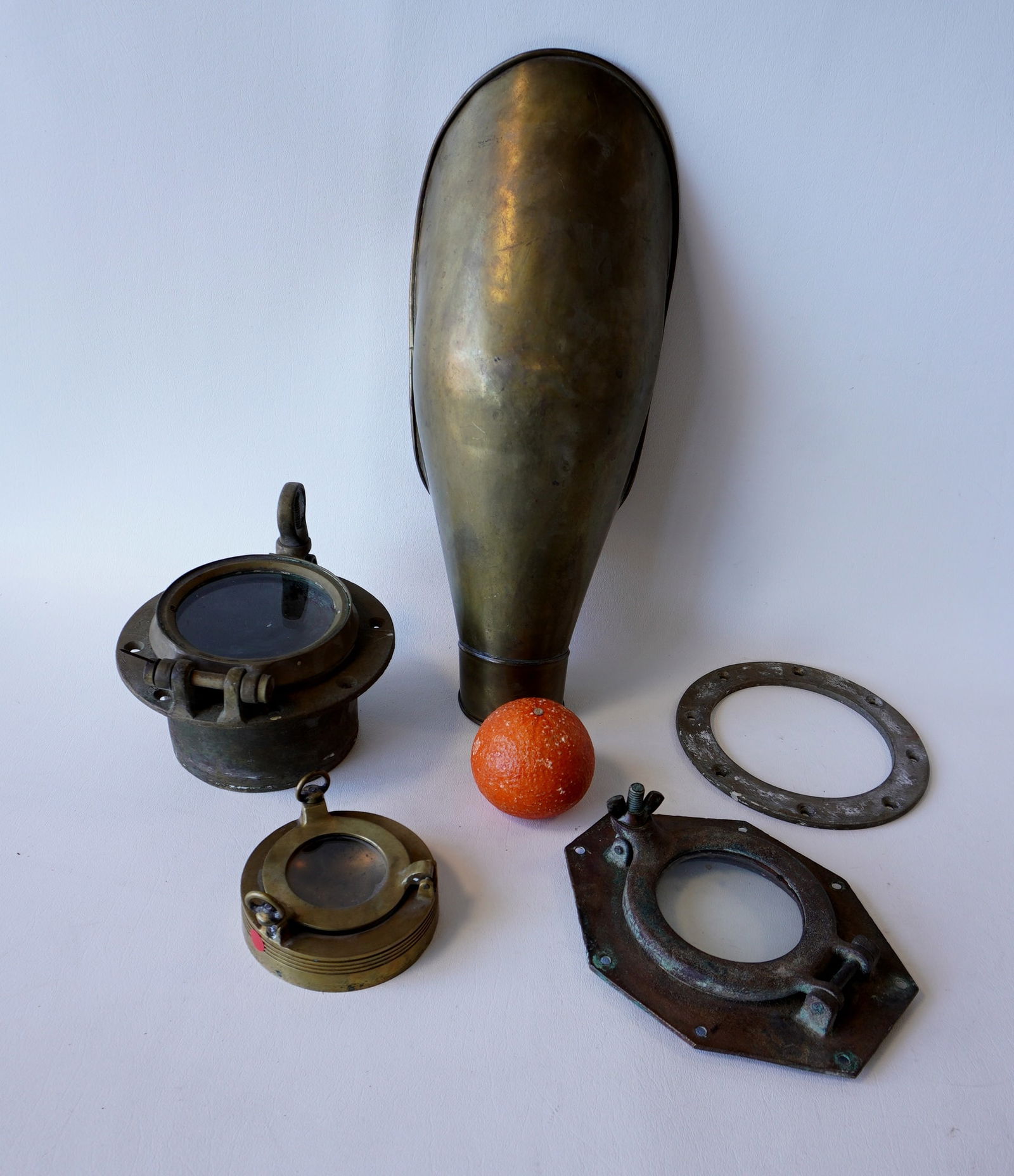 Five brass marine collectibles including a ship's air vent - this is the largest in the lot: Five brass marine collectibles including a ship's air vent - this is the largest in the lot measuring 16"L x 7"W, 3 portholes, and 1 brass porthole frame. All in good condition. Provenance: From the e