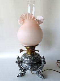 A fancy Victorian table oil lamp, electrified, profusely decorated with leaves, flowers, scrolls and