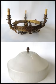 A classical architectural style chandelier having a circular apron with embossed decorations that