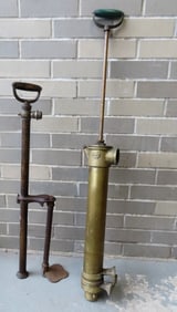 Two brass bilge pumps that appear to be in working order. One signed illegibly and one with monogram