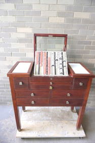 A Bausch and Lomb mahogany optometrist chest having a lens display case in the center under glass