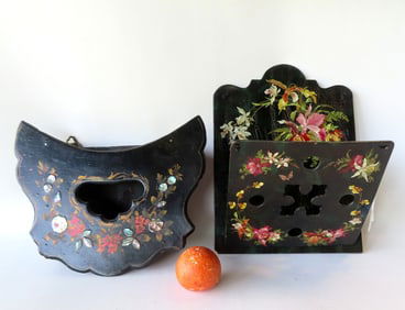 Two black lacquered 19th century wall hanging units. The first a paper mache magazine rack decorated