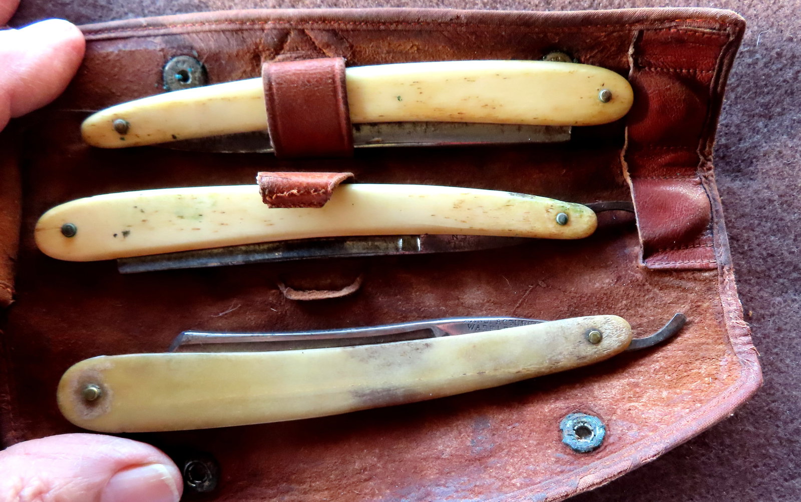 Three straight razors with animal horn and bone handles, circa late 19th to early 20th century. Two: Three straight razors with animal horn and bone handles, circa late 19th to early 20th century. Two signed "Oxidene / H.H. Hill / Solingen Germany" (Oxidene company active 1913); and one marked "Manuf