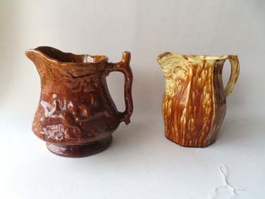 Two spongeware pitchers, probably Bennington. The first, a light brown sponge over yellowware having