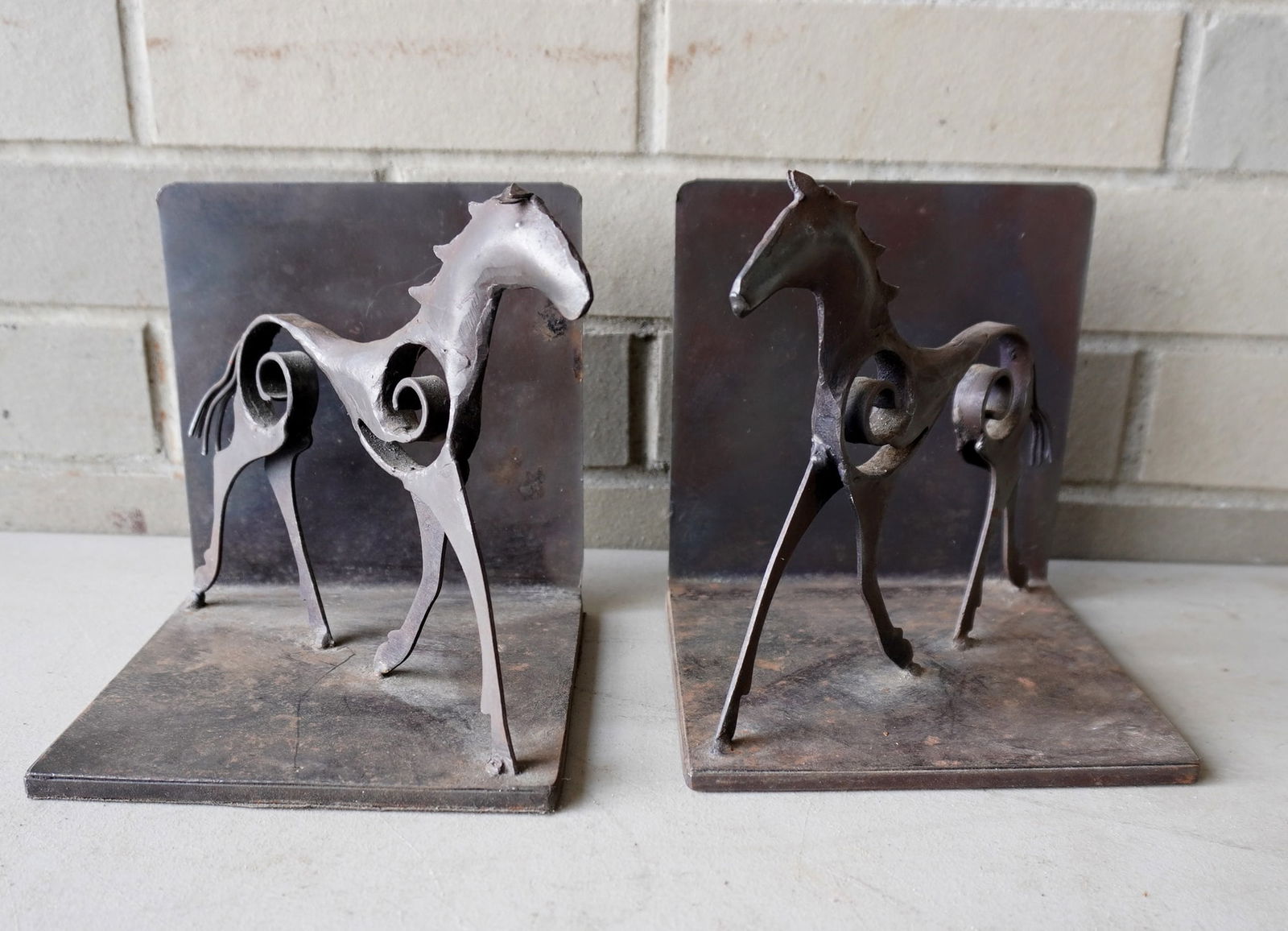 Pair of metal stylized horse bookends, hand made, probably late 20th century. Good condition.: Pair of metal stylized horse bookends, hand made, probably late 20th century. Good condition. Measures 6"W x 6"D x 6 1/2"H.