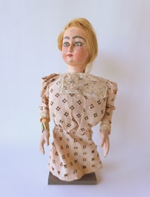 A mechanical folk art ventriloquist wooden doll with head that can be moved from left to right or up