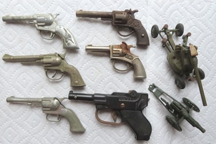 Grouping of 6 vintage cap guns and 2 vintage "Britains Ltd. London" diecast howitzers (missing