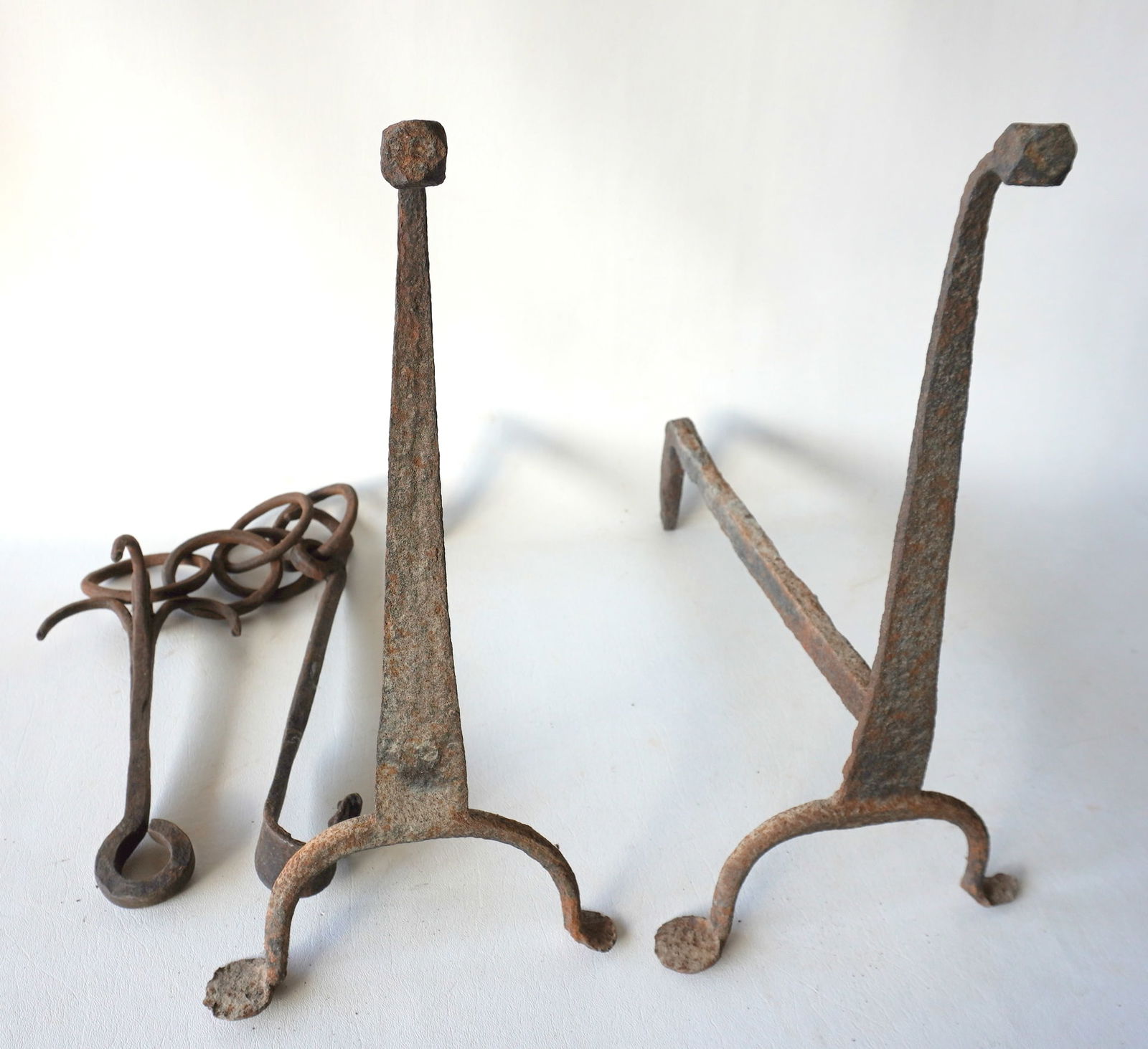 A pair of Queen Ann hand forged goose neck andirons with penny feet - some rusting and pitting in: A pair of Queen Ann hand forged goose neck andirons with penny feet - some rusting and pitting in poor to fair condition - measures 16 1/2"H x 15 1/2"D; together with a primitive hand forged iron chai