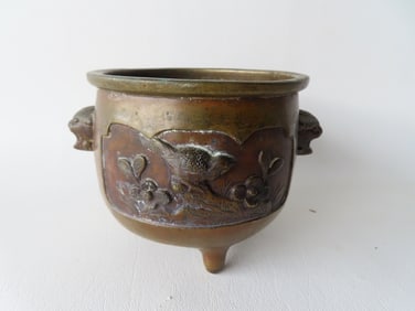 A very fine small oriental patinated bronze pot, decorated with 2 embossed images of flowers and