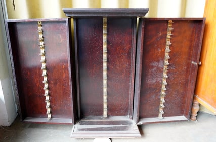 A mahogany storage cabinet with interior fittings probably for holding player piano rolls and having