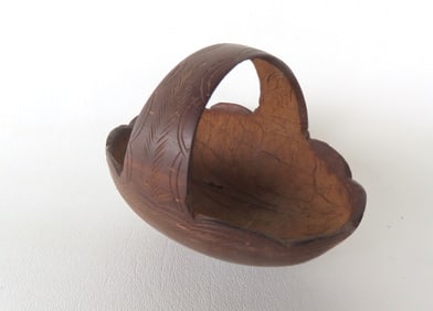 Sailor art. A small carved dark brown coconut shell whimsy in the form of a small basket with