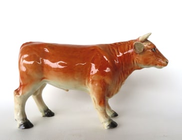 A high quality hand painted porcelain standing cow figurine. Japan, circa 1940-50.