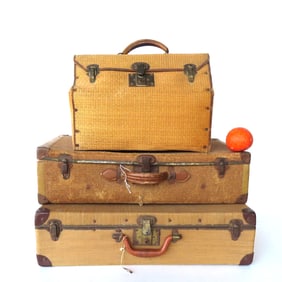Three rattan suitcases. Two with normal use wear, and one with wear and slight loss to woven rattan