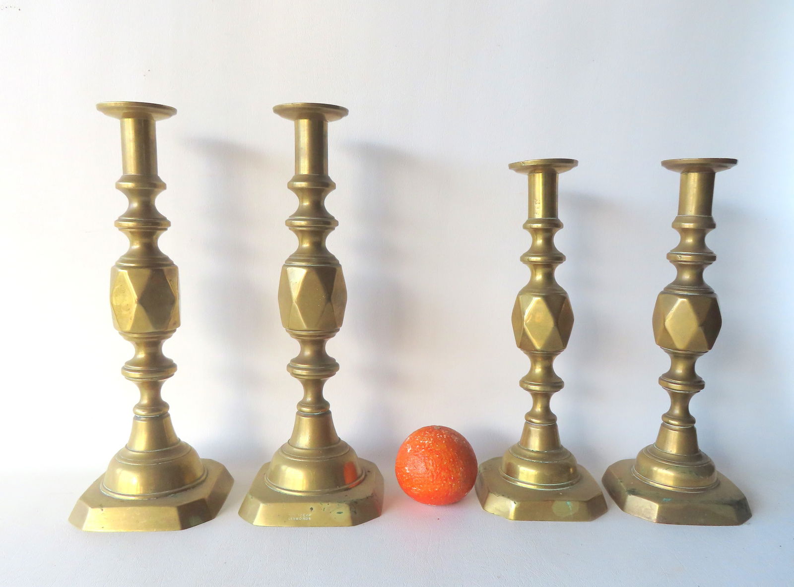 Two pair of English brass pushup candlesticks in the diamond pattern. The larger pair, 14"H, marked: Two pair of English brass pushup candlesticks in the diamond pattern. The larger pair, 14"H, marked "The Ace of Diamonds". The smaller pair, 12 1/2"H, marked "The King of Diamonds". Both in good condi