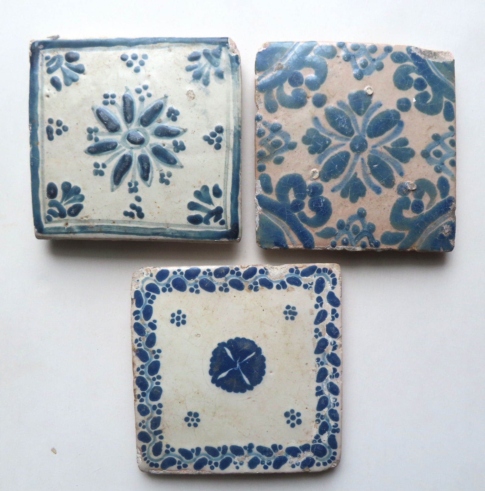 Three early blue and white tiles, all hand made and hand painted decorated with flowers, 18th/19th c (1 of 3)