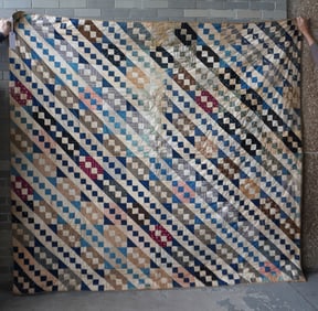 A patchwork quilt hand sewn, early to mid 20th century. Small area with faded fabric, stain on borde