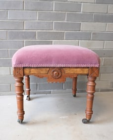 A Victorian walnut Eastlake stool with velvet top on original casters, late 19th century. Measures 1