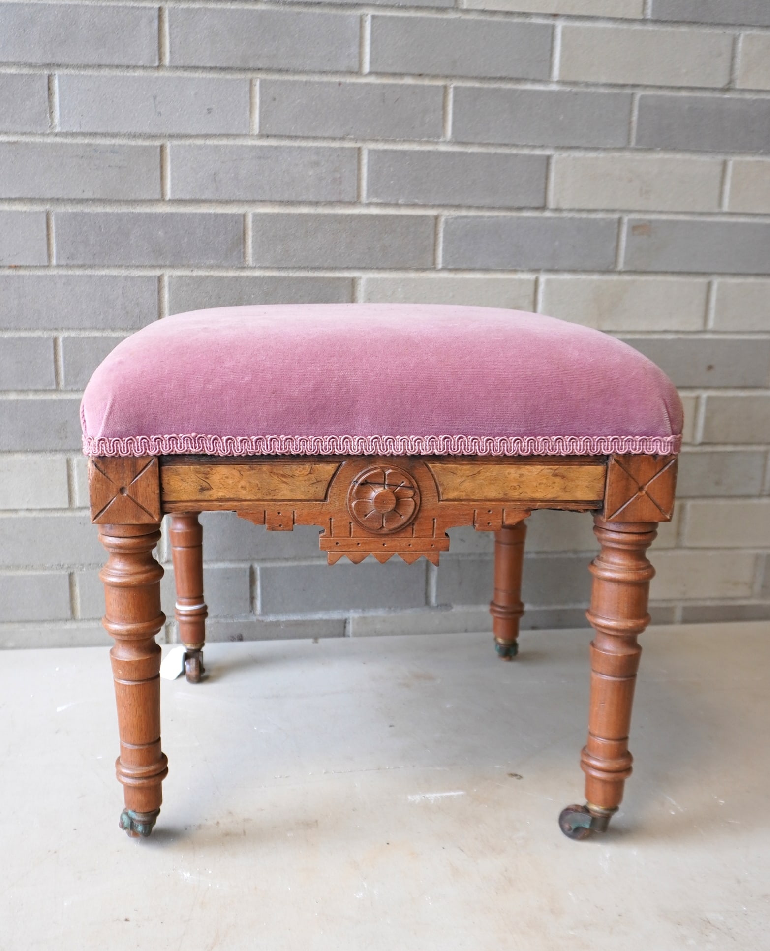 A Victorian walnut Eastlake stool with velvet top on original casters, late 19th century. Measures 1: A Victorian walnut Eastlake stool with velvet top on original casters, late 19th century. Measures 15" square x 15 1/2"H.