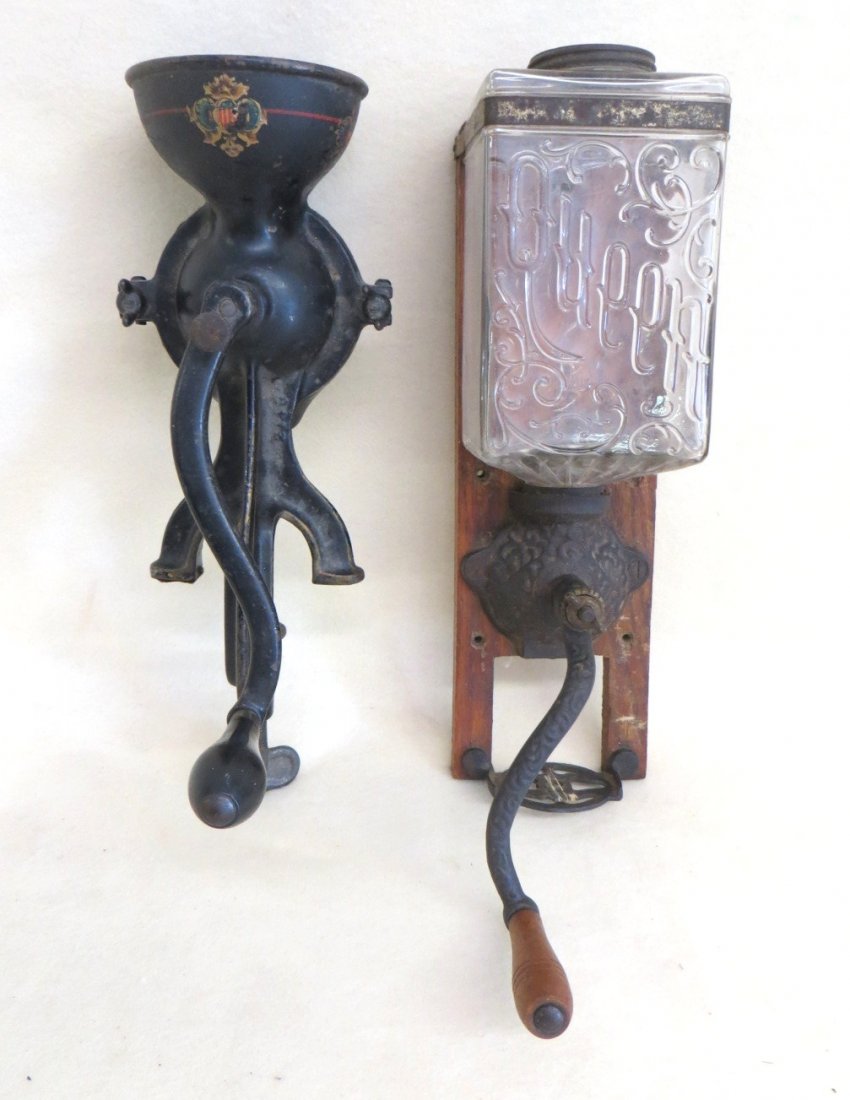 Two coffee grinders including cast iron Enterprise no. : Two coffee grinders including cast iron Enterprise no. 0 with table mount in original paint and stenciling, the other wall mounted with embossed glass holder signed Queen.