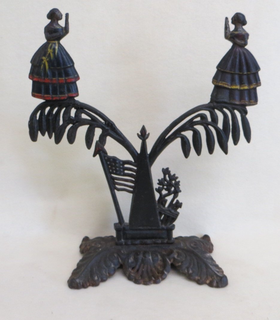 Cast iron Jenny Lind mirror holder with American flag, : Cast iron Jenny Lind mirror holder with American flag, tree, and 2 Jenny Lind figures - 19th century - appears to retain original paint. - several repairs to tree - 16.25"H x 14.5"W