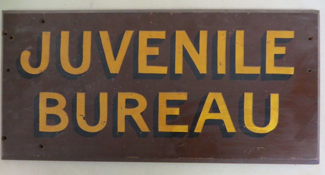 Old wooden sign in original brown, yellow and black pai: Old wooden sign in original brown, yellow and black paint entitled "Juvenile Bureau". 11.5" x 24"