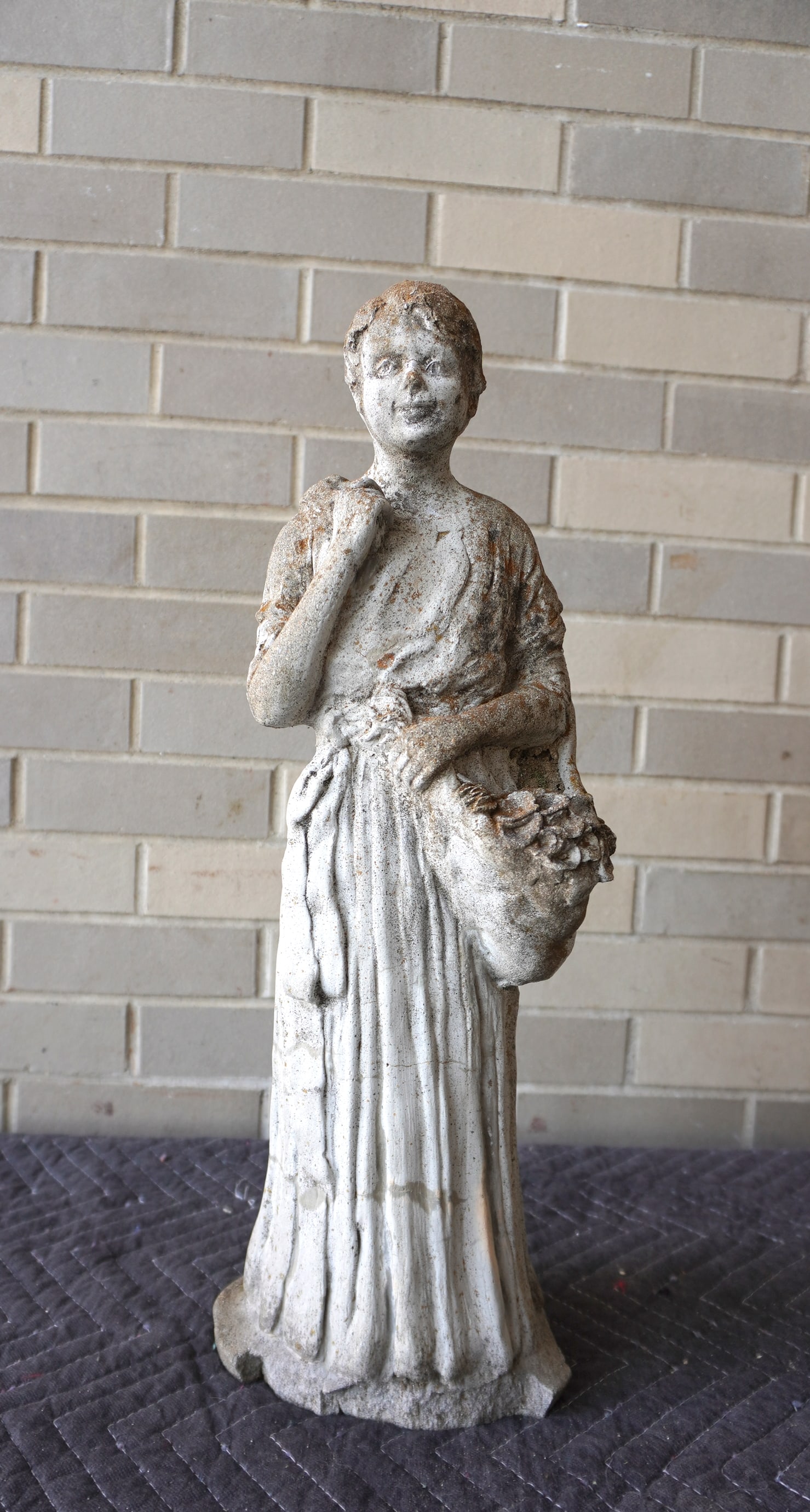 A concrete sculpture of a flower girl, probably mid 20th century - loss at circular base, otherwise: A concrete sculpture of a flower girl, probably mid 20th century - loss at circular base, otherwise good condition. Measures 8"W x 6 1/2"D x 21 1/4"H.